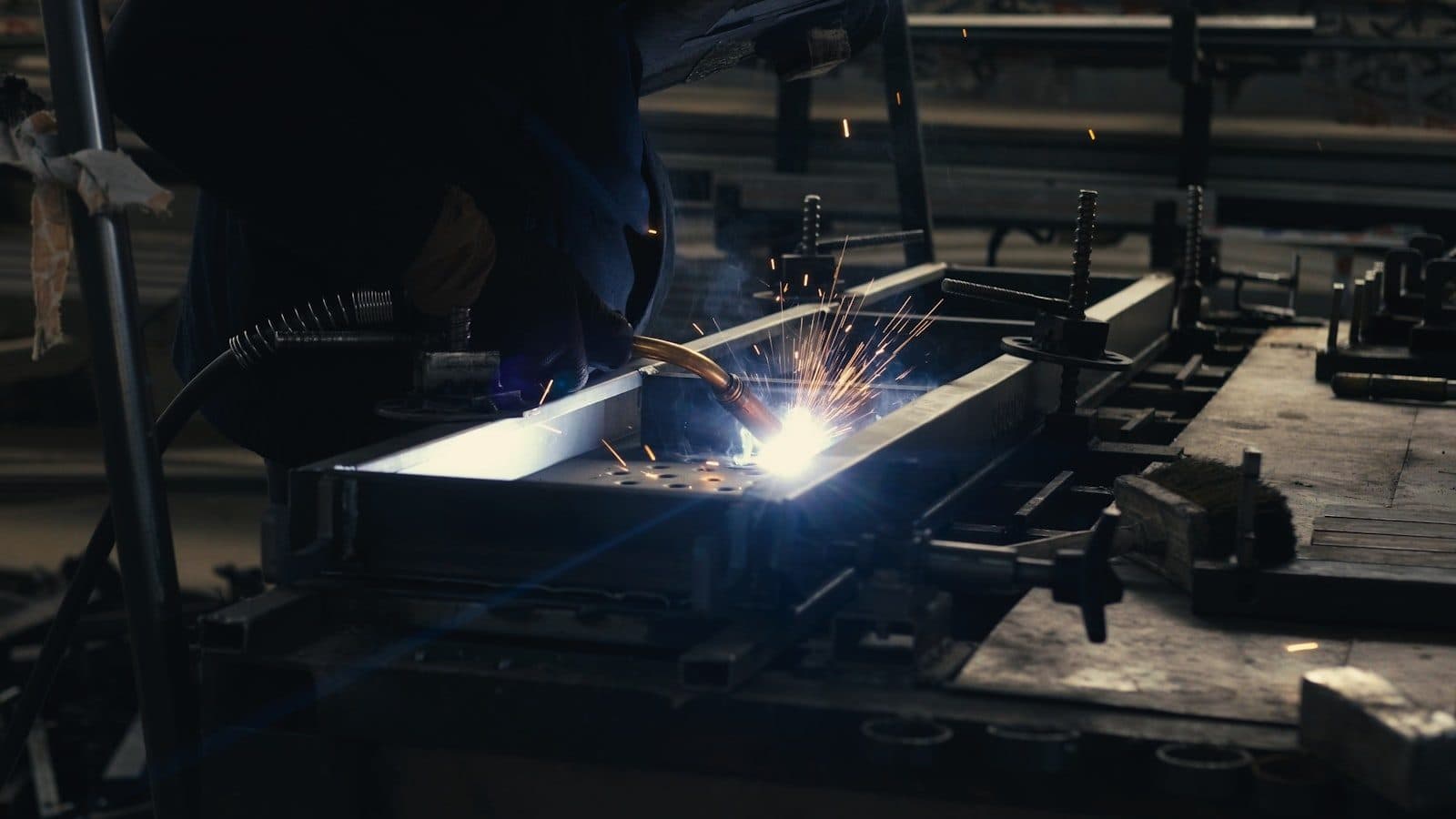 Sparks from a cutting torch in a darkened metal fabrication shop