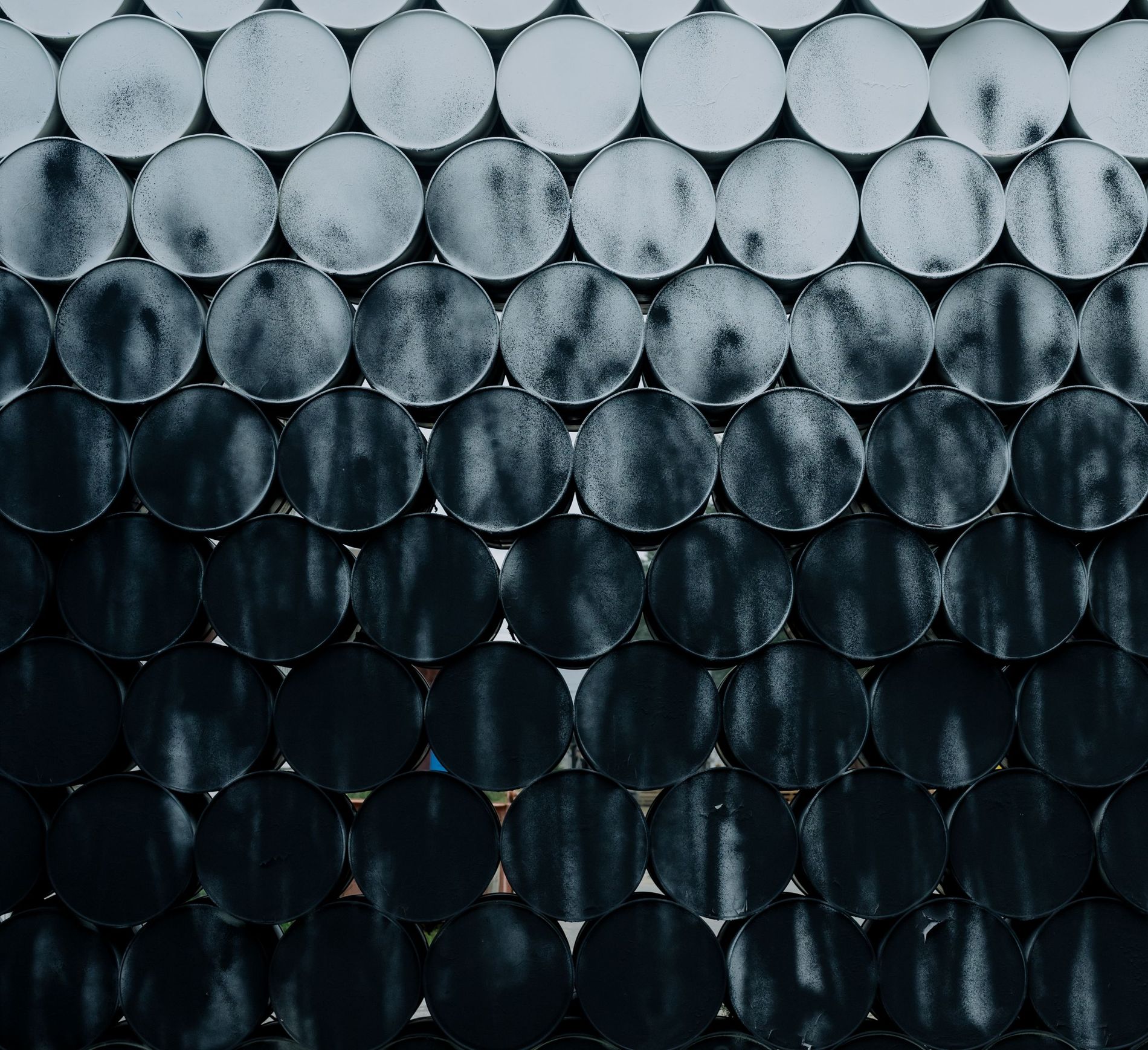 A wall of stacked steel drums seen end-on